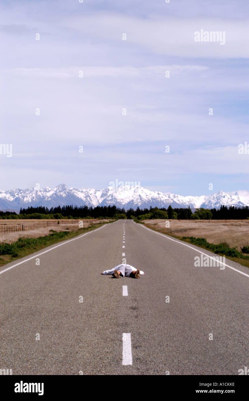 Man Lying Down In Road After Long Walk And Long Way To Go Stock Photo Alamy