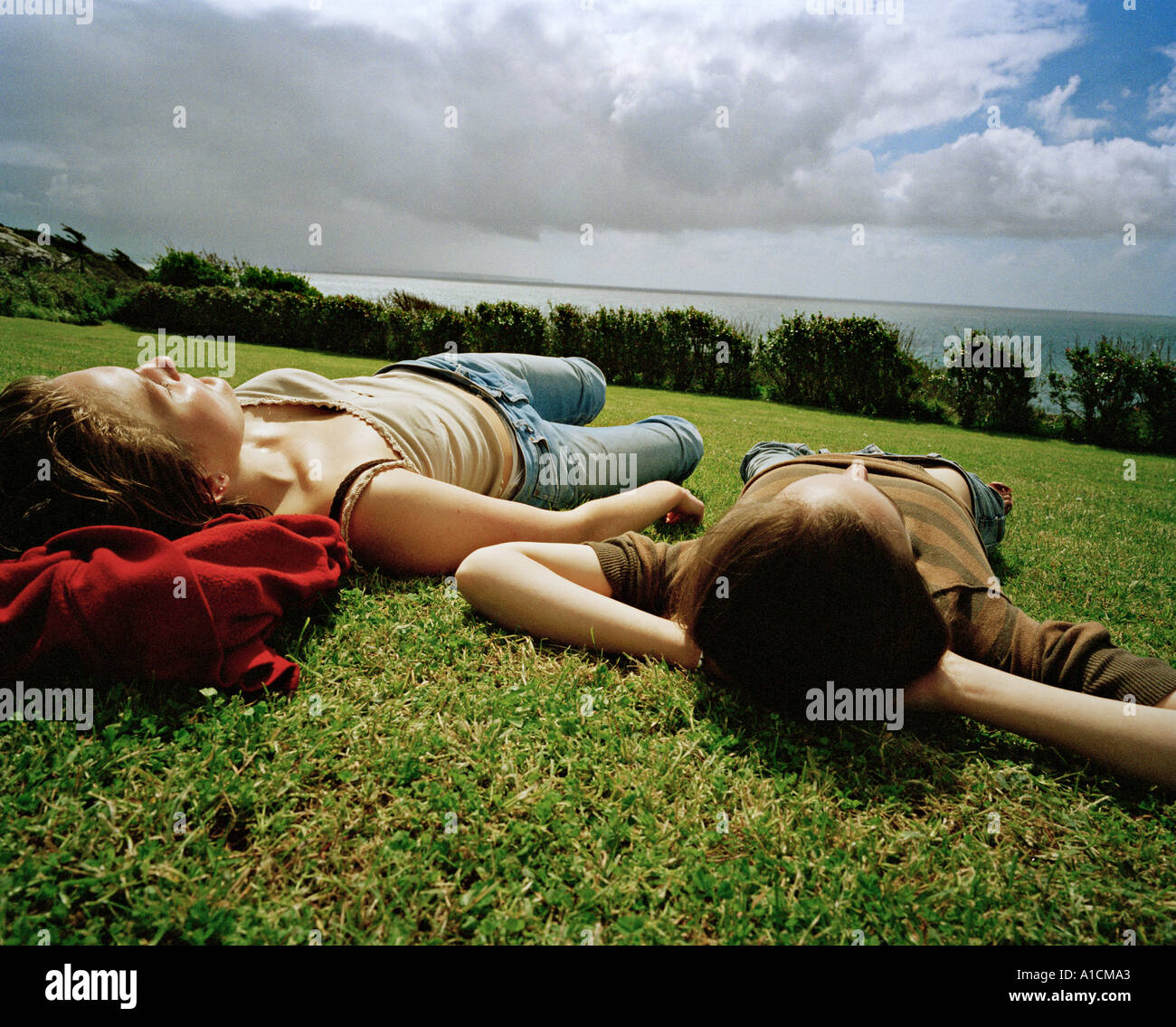 Young women sunbathing on lawn Stock Photo