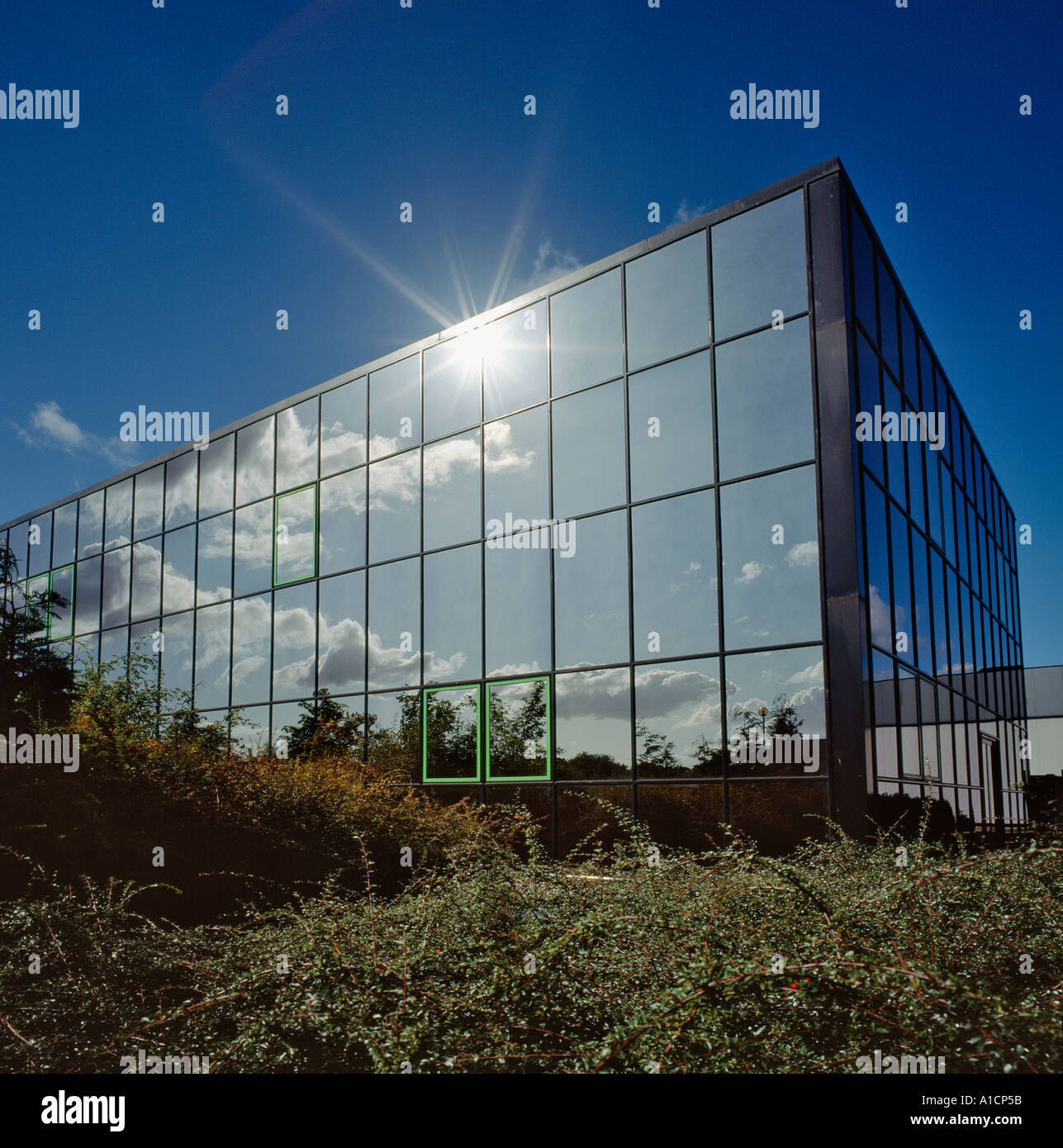 CLOUDS AND SUN REFLECTED IN GLASS WALLED OFFICE BUILDING UK Stock Photo ...