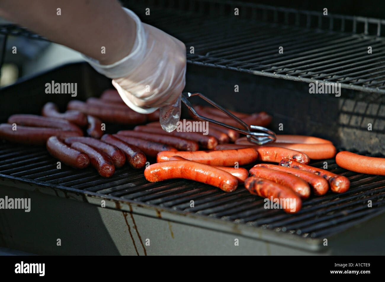 Cooking hot dogs on outdoor grill Stock Photo Alamy