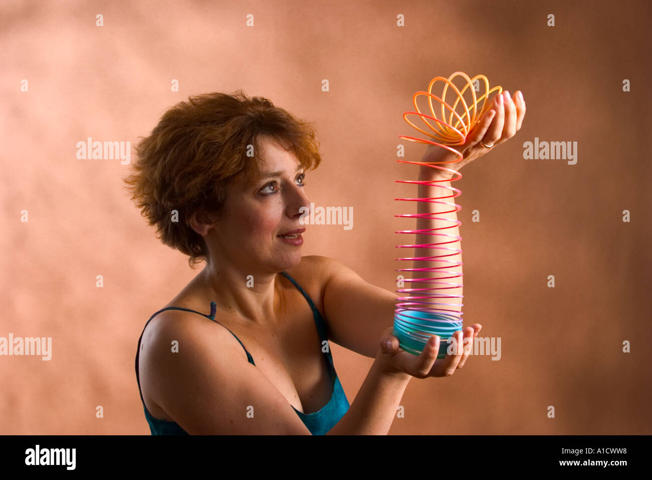 Woman playing with a slinky toy Stock Photo