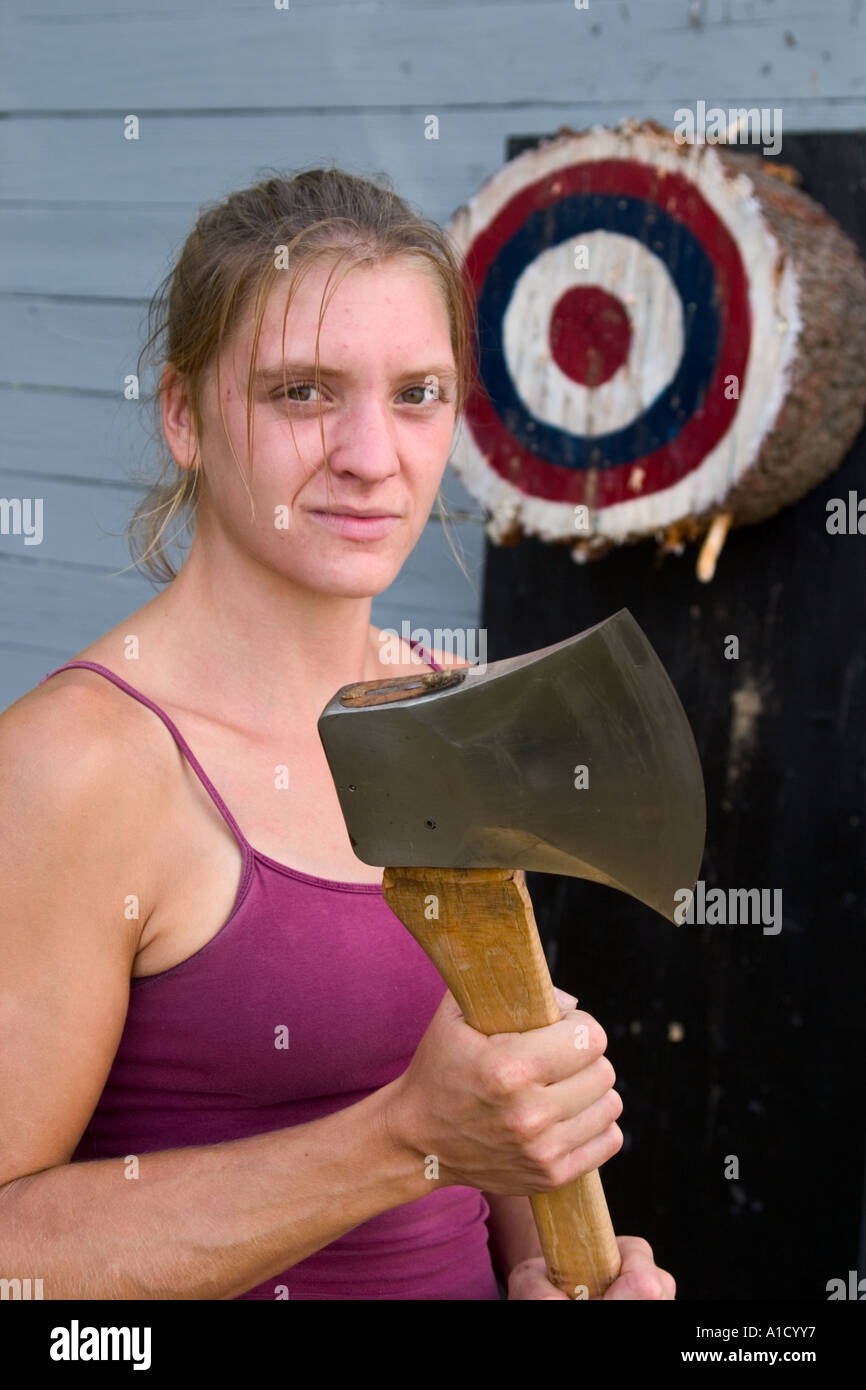 Young female wood chopping competitor holding her ax next to an ax throwing target at a fair in Connecticut, USA. Stock Photo