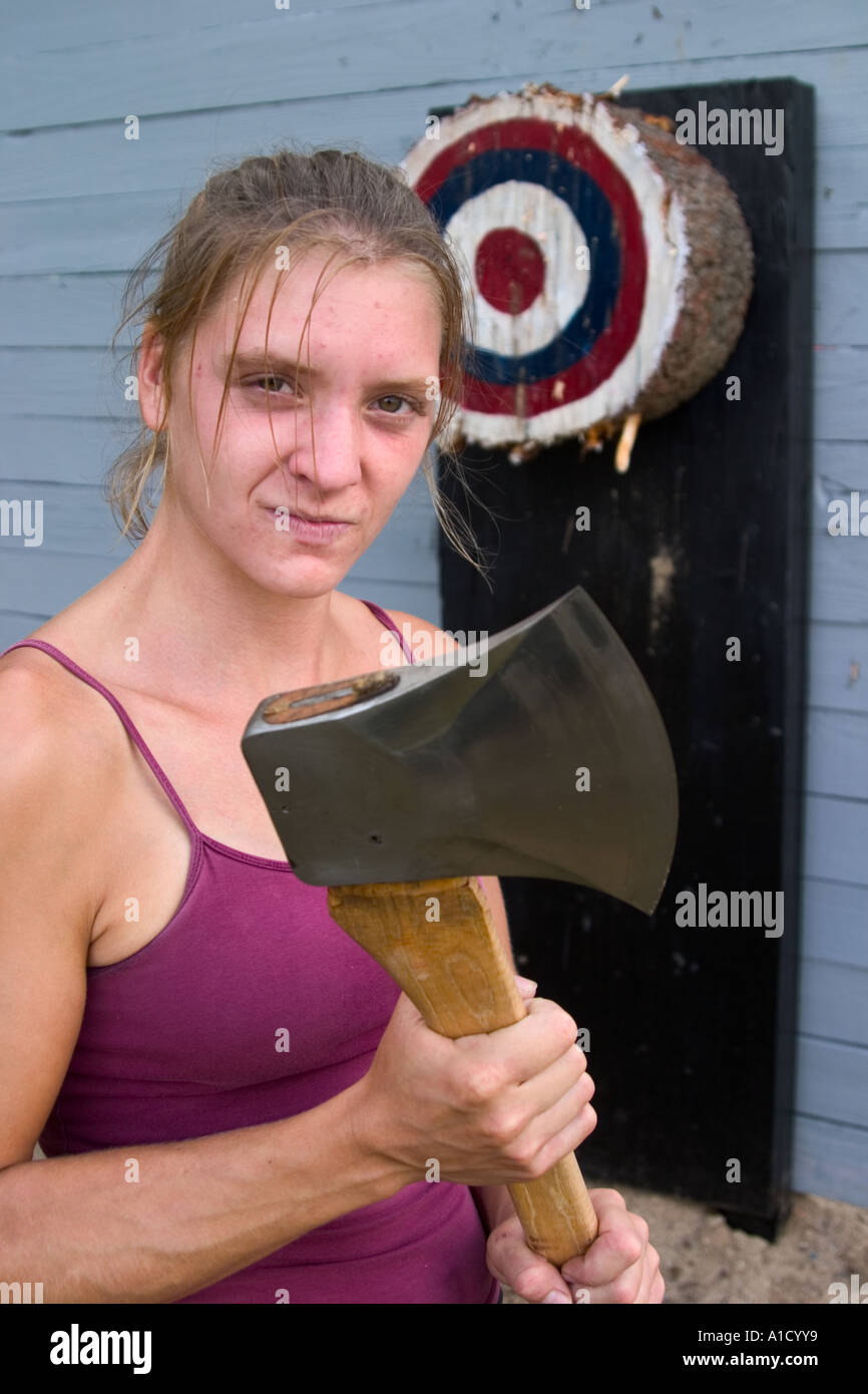 Young female wood chopping competitor holding her ax next to an ax throwing target at a fair in Connecticut, USA. Stock Photo