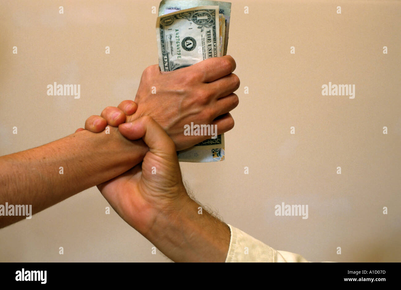 Hand grabbing another person's fistful of money. Stock Photo