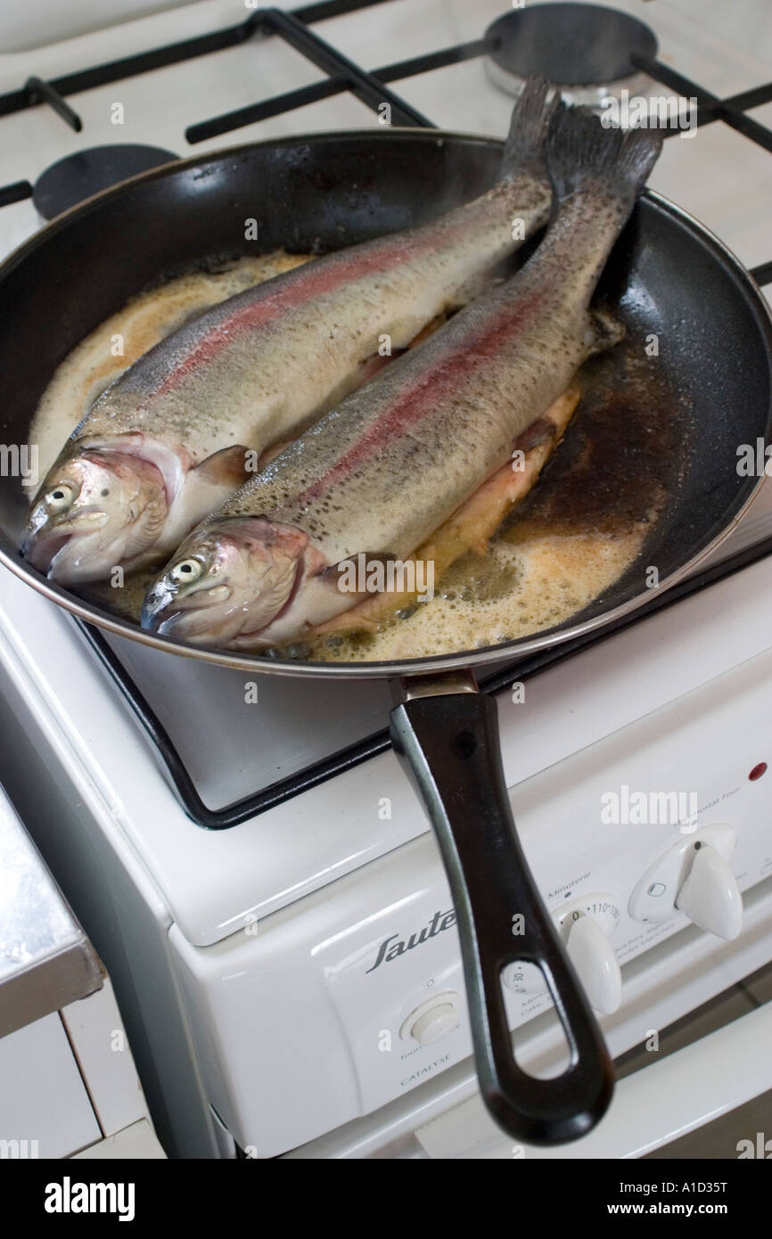 Pair of fresh trout in frying pan being cooked on French Sauter gas