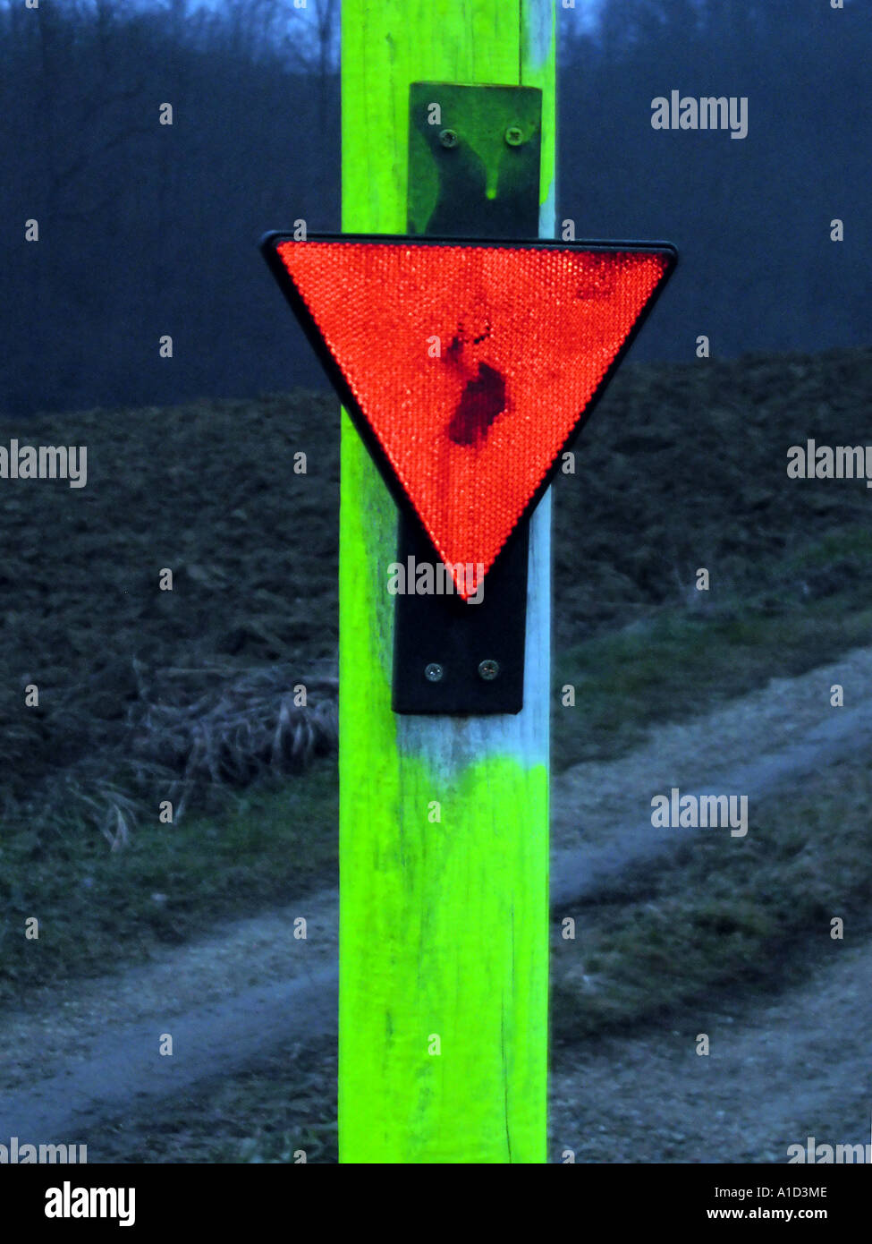 Red triangle signal on a post on the side of a lane Stock Photo - Alamy