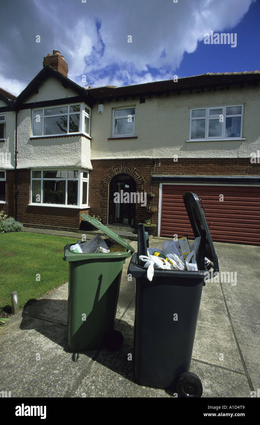 household rubbish bin alongside green recycling bin outside house