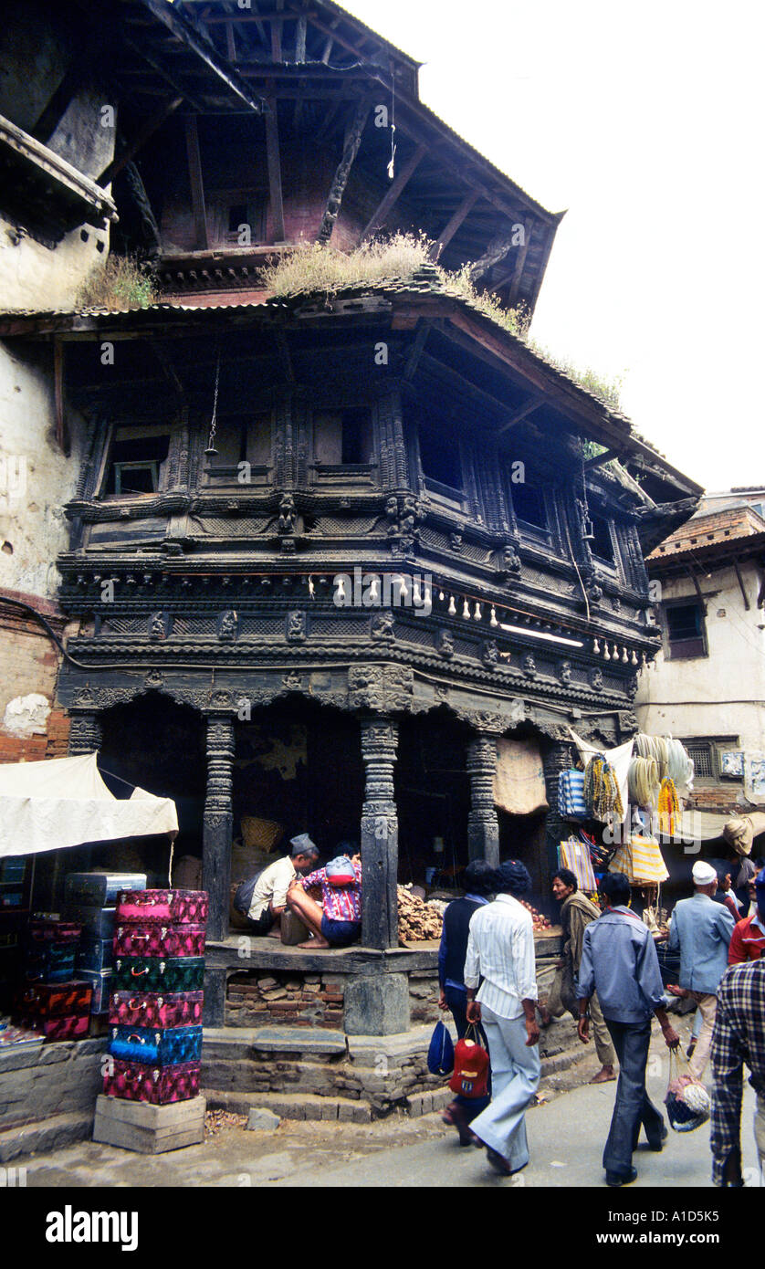 Wood carved heritage disrepair shop house three story dwelling old unpainted natural black street public road men walk stroll Stock Photo