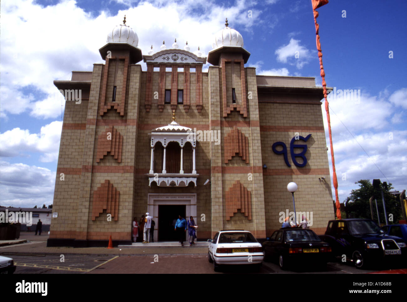Exterior of a Sikh temple or gurdwara at Hounslow England with the Nishan Sahib, Sikh flag Stock Photo