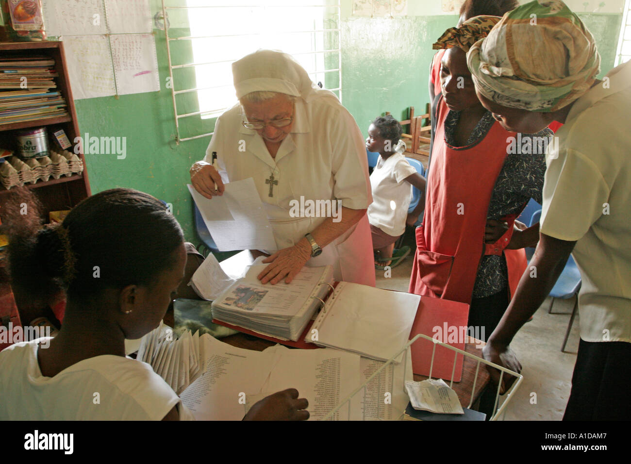 Catholic Nun dispensing money to families at Liteta Leper Invalid Compound in Lusaka Zambia Stock Photo