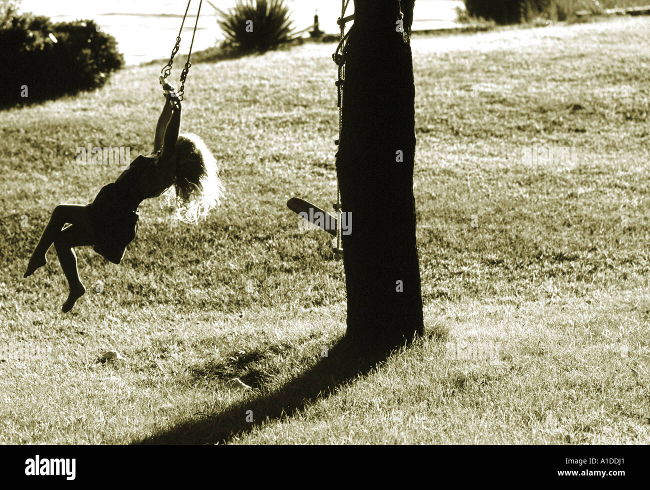 Side profile of a girl sitting on a swing Stock Photo - Alamy