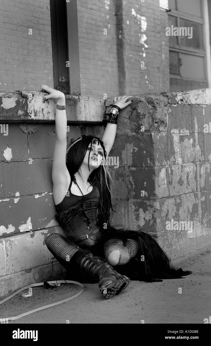 Goth girl sitting in alley Stock Photo