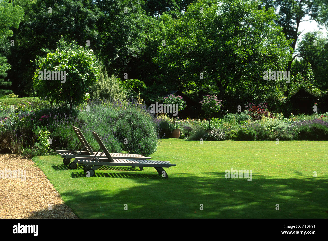 large wooden deck loungers on the lawn of a large garden Stock Photo ...