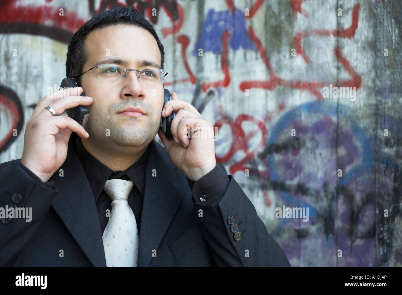 Businessman is calling in front of an graffiti wall Stock Photo