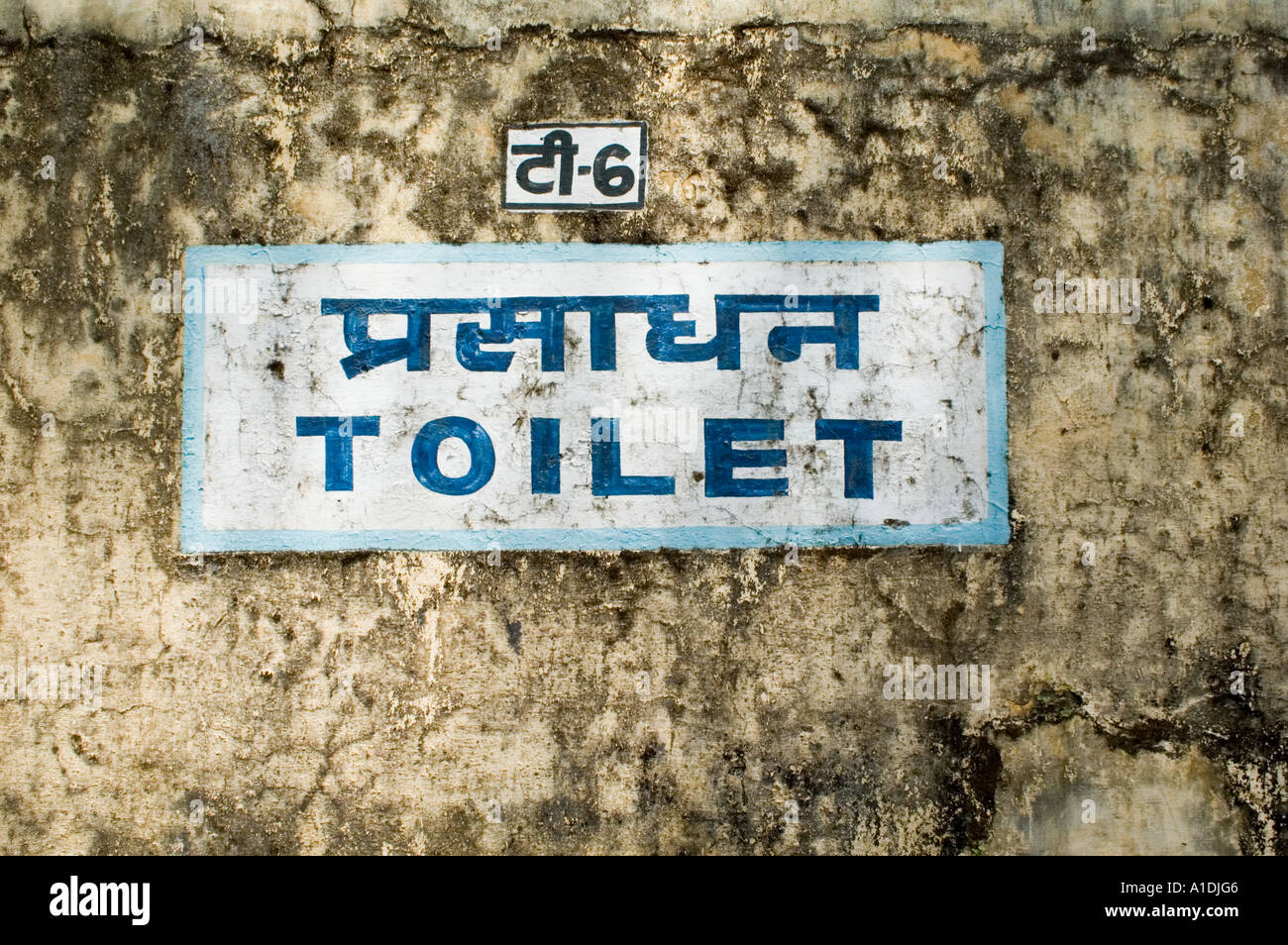 Taoilt sign bith hindi and english on Shimla Kalka reilway station. A weathered wall with bilingual toilet signage in India. Stock Photo
