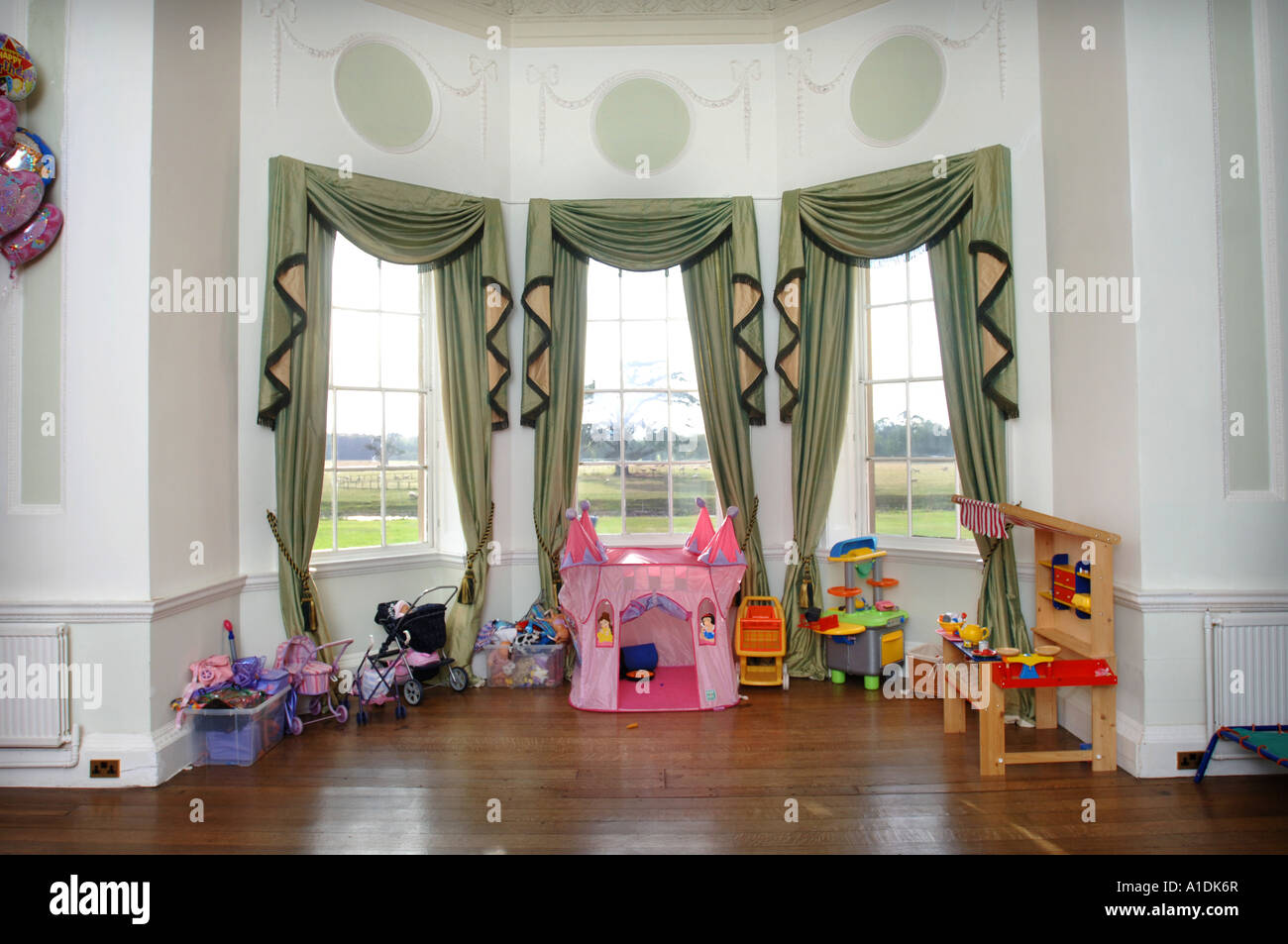 TOYS STORED IN LARGE BAY WINDOW IN A CHILDRENS PLAYROOM IN A LARGE