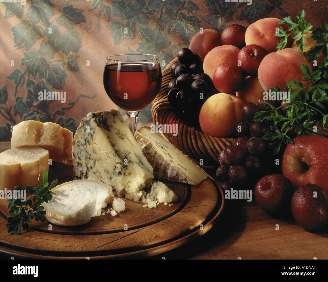 Still life of fruit cheese and wine Rich lowkey dappled light landscape format Original shot on 5x4 trans Stock Photo