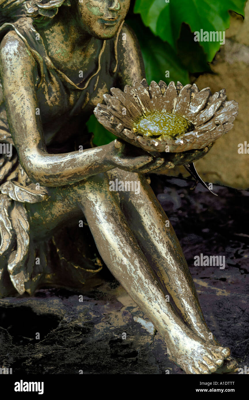 Brass fairy statue sitting and holding flower bowl Stock Photo Alamy