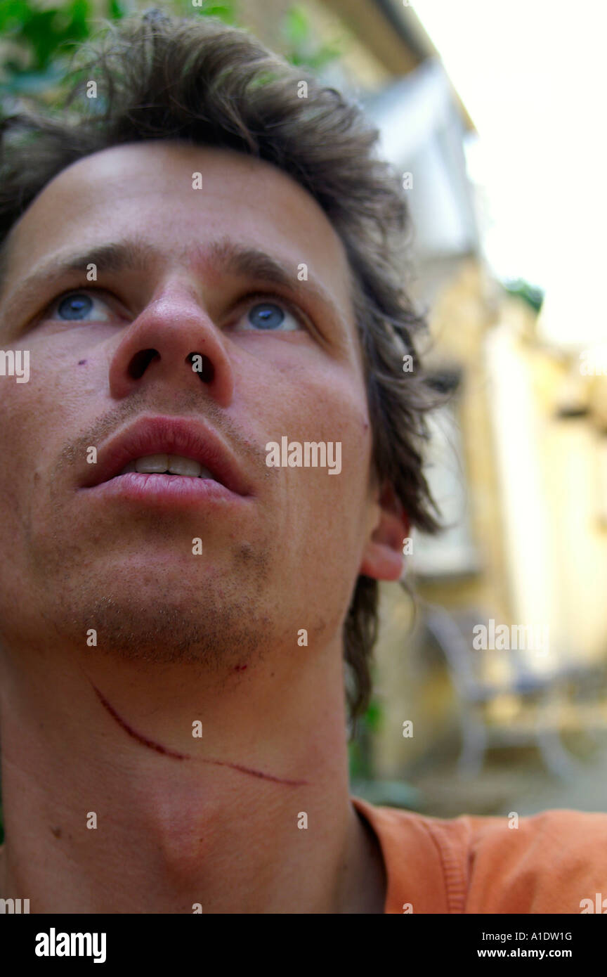 Man boy face looking upwards with knife wound on his neck sucidal