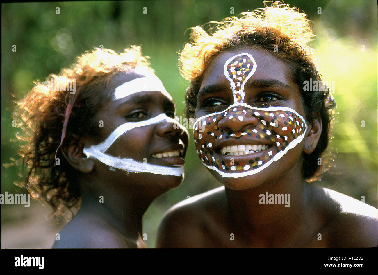 Aboriginal sisters Tessa and Jane enjoy painting their faces with their clan motives and totems at remote Ramingining ArnhemLand Stock Photo