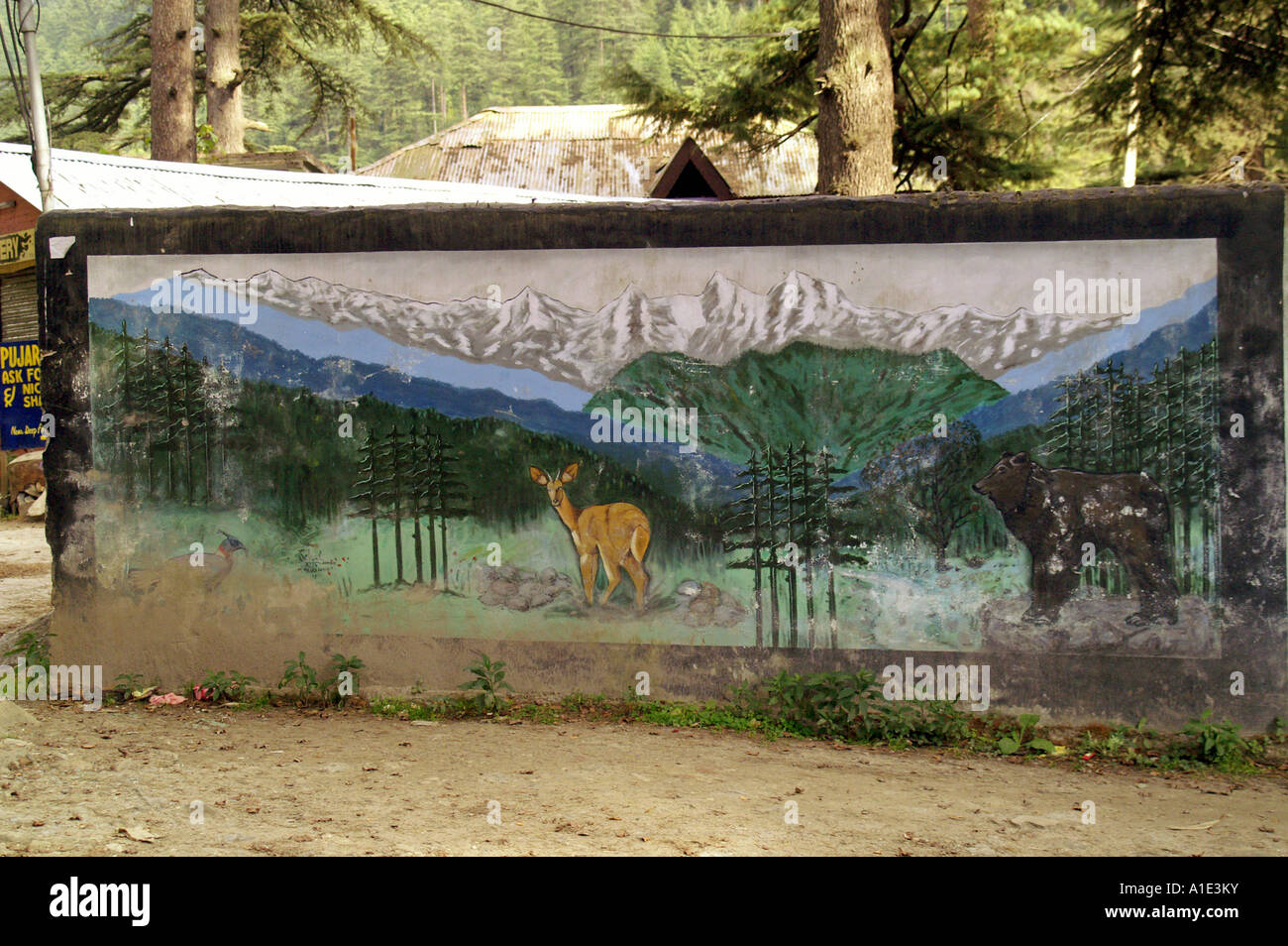 Concrete wall in Kasol indian village with quiche painting of bear and doe in mountians meadow Himalaya Stock Photo