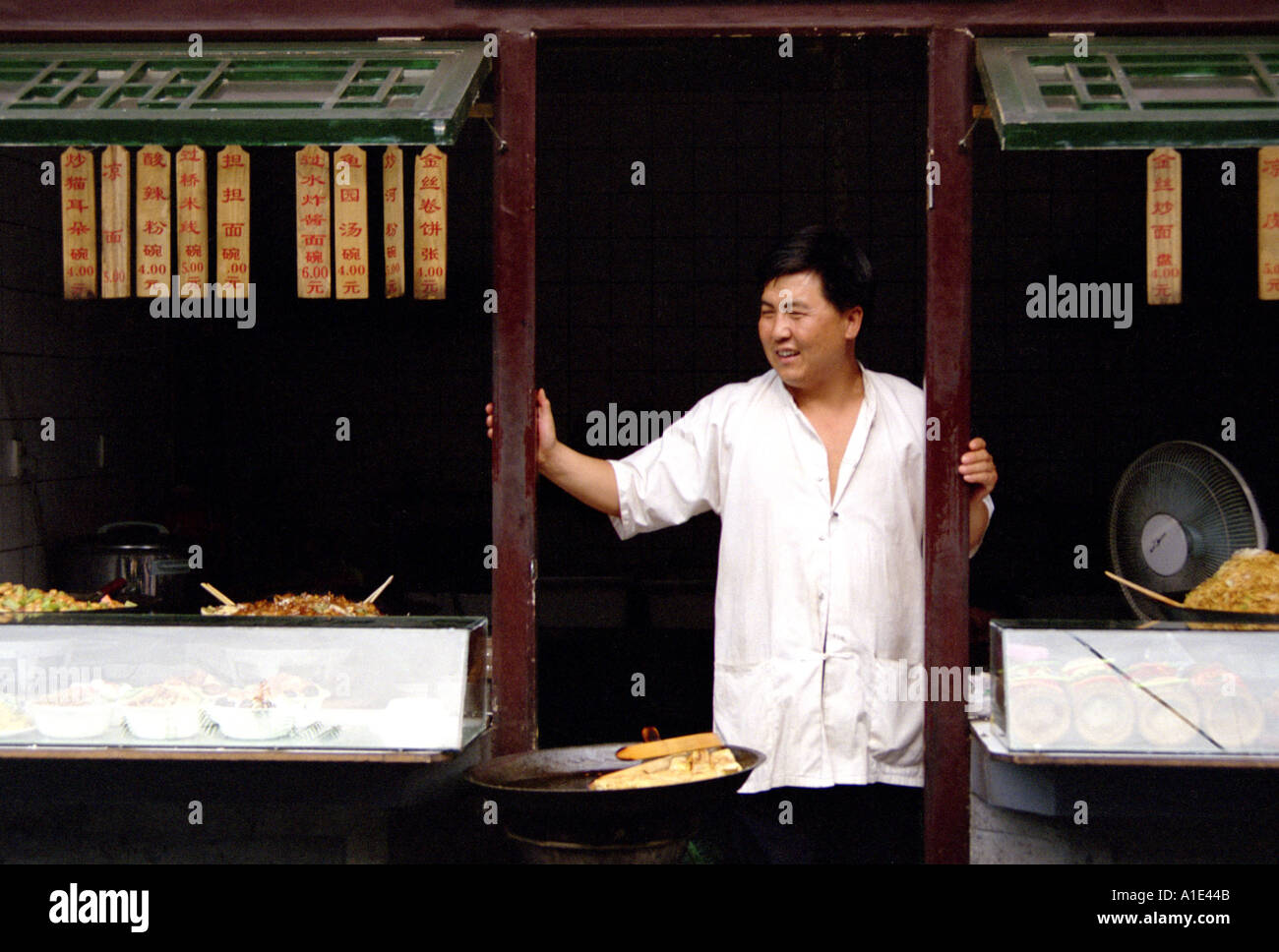 Food stall chef stands by his shop along Wangfujing district in Beijing, China Stock Photo