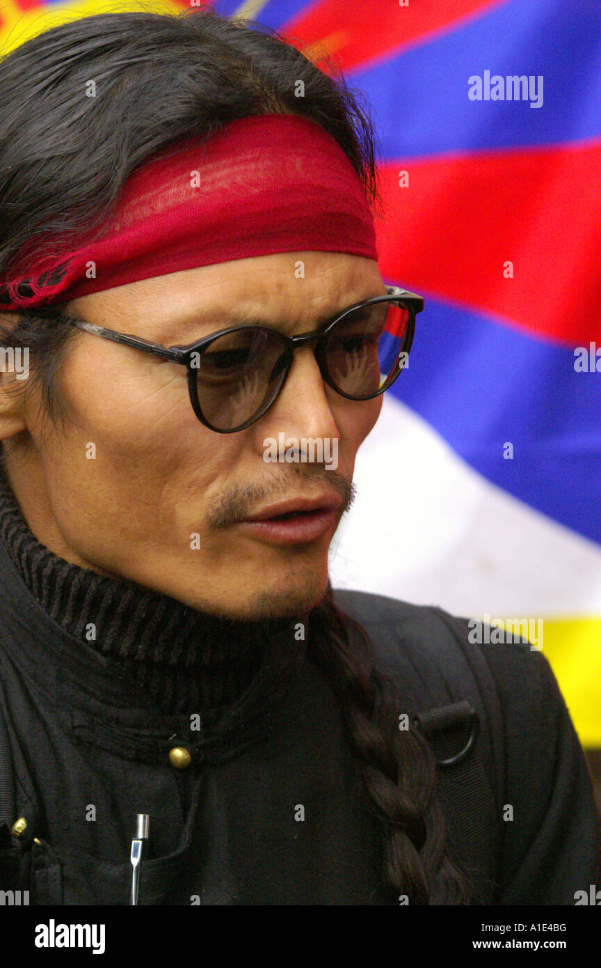 Portrait of tibetan Tenzin Tsundue political activist discussing politically sensitive issue on backdrop of tibetan flag Stock Photo