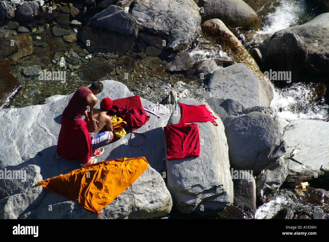 Tibetan buddhist monk man doing massage on boulder in mountain