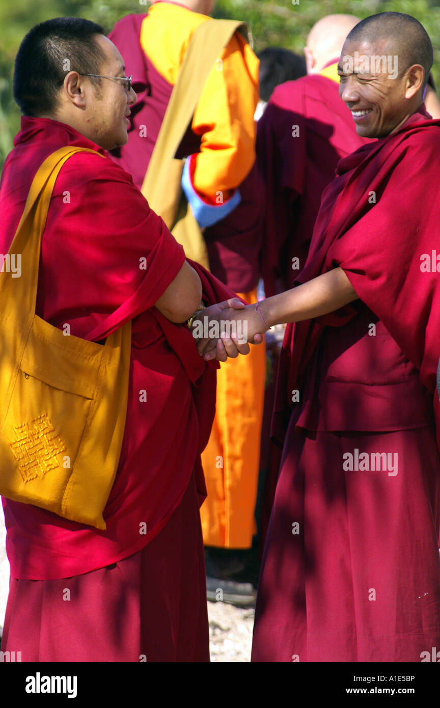 Two tibetan monks buddhists shaking hands in reaching final important