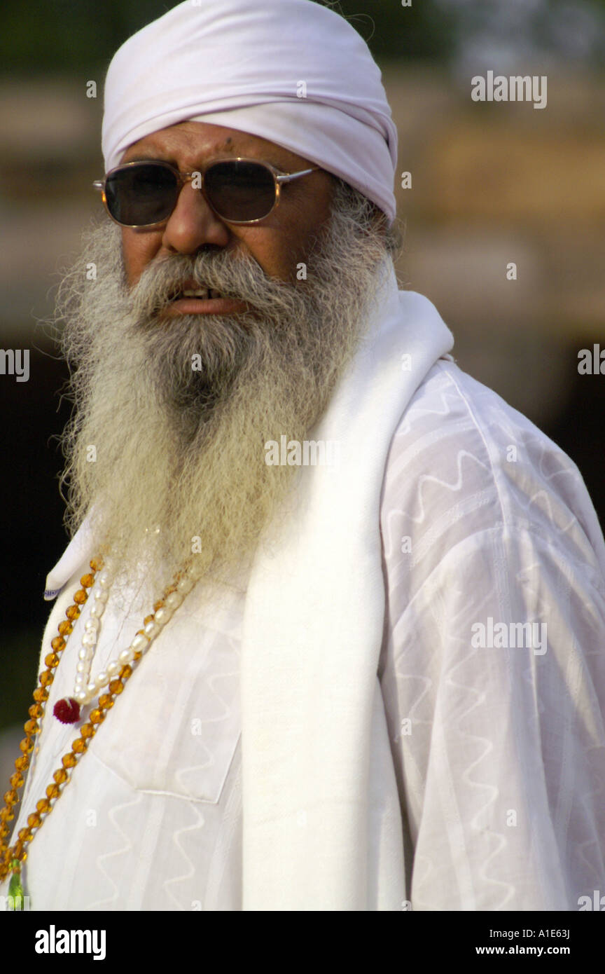 Sikh guru in traditional white dress with beads at Qutb Minar site in New Delhi Stock Photo