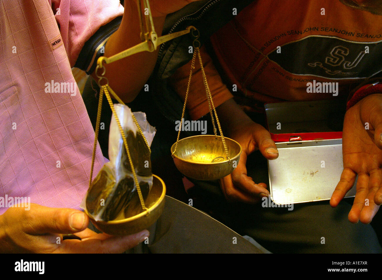 Two men weighing hashish variety called Malana Cream with hand scales in Malana village,  Indian Himalaya Stock Photo