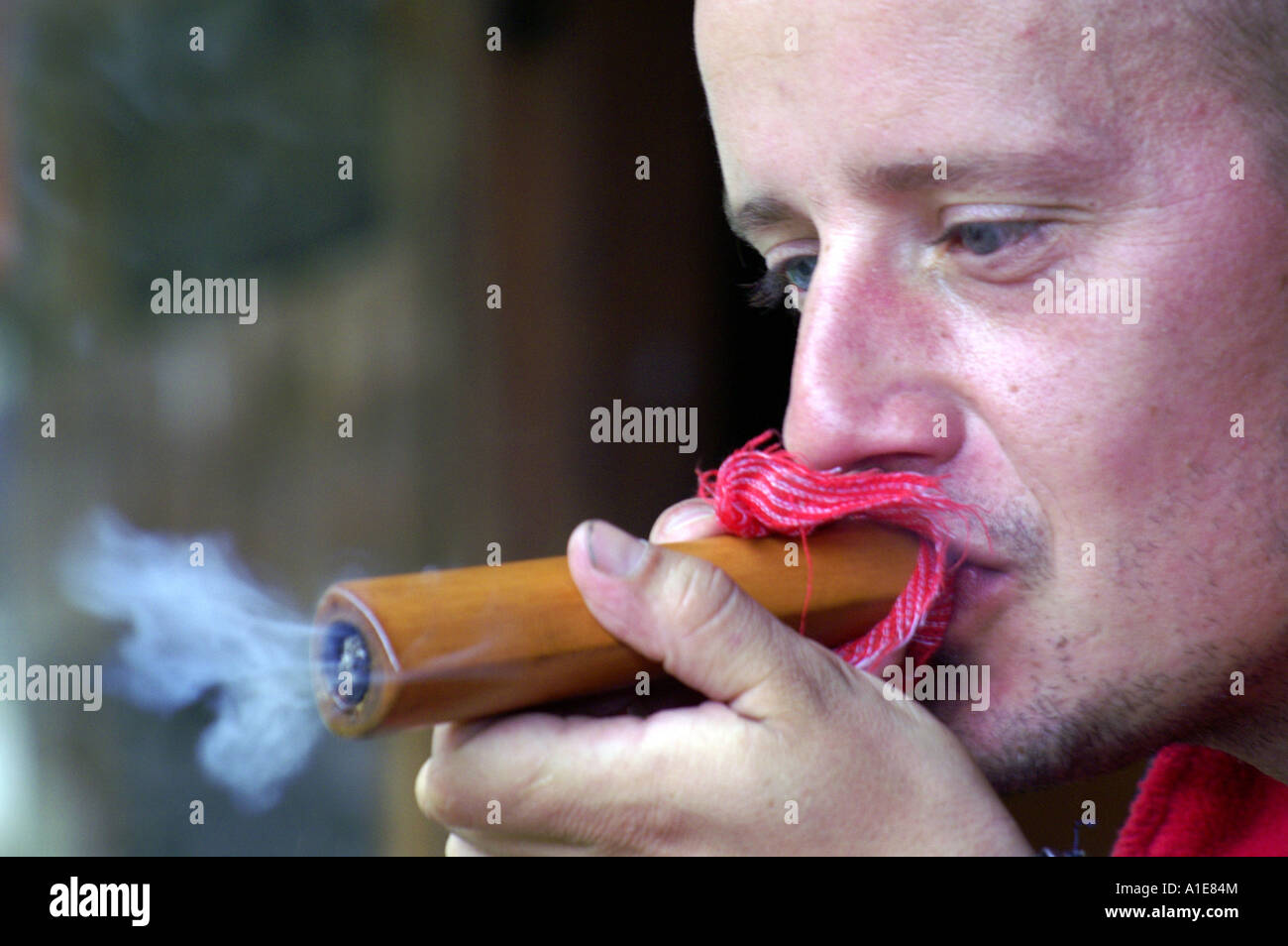 Western tourist boy teenager smoking traditional holy hashish chilum pipe in Malana village, India Stock Photo
