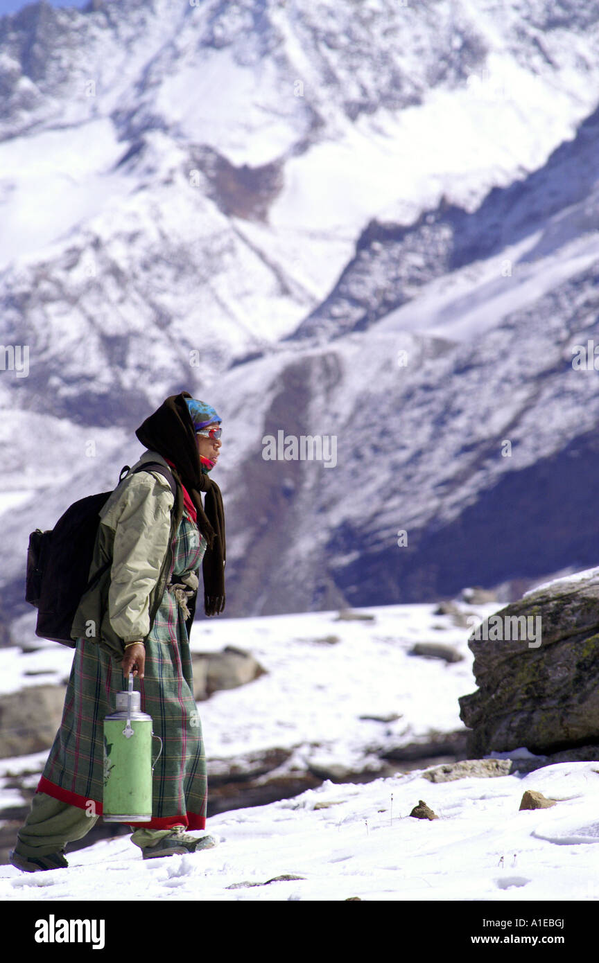 Old indian woman with cofee flask on snow in Indian Himalaya, Rohtang Pass in Lahaul region Stock Photo