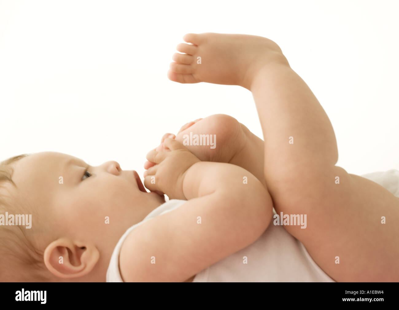 Baby putting foot in mouth Stock Photo