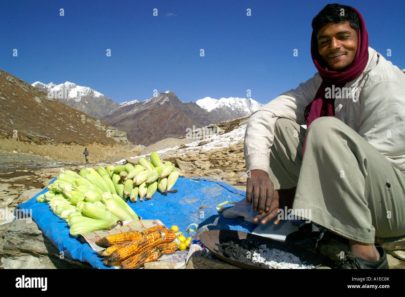 Indian man selling roasted corn on snow in Indian Himalaya, Rohtang Pass in Lahaul region Stock Photo