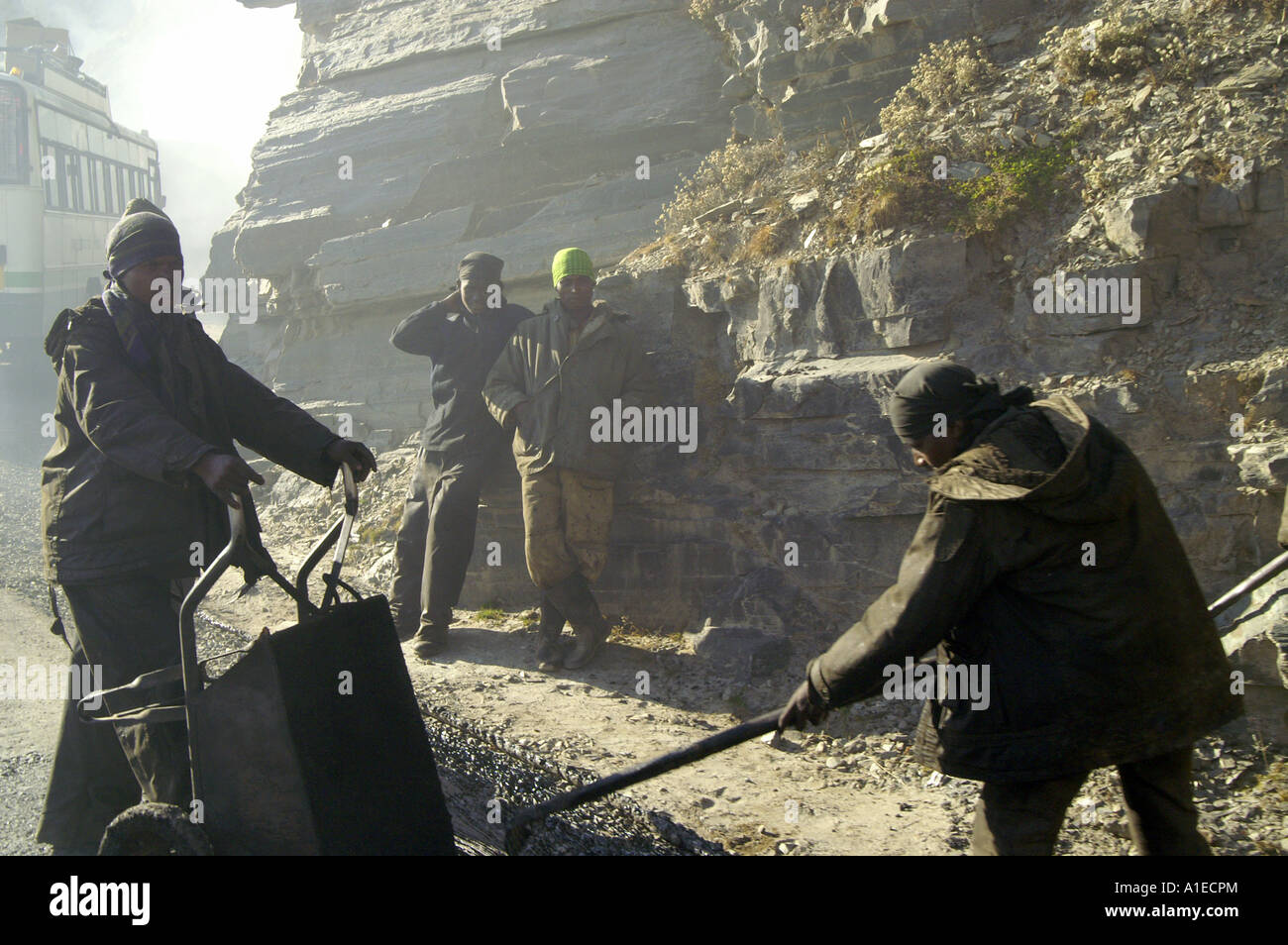 Men asphalting road leading to Rohtang pass at the end of Kullu Valley, Indian Himalaya mountains Stock Photo