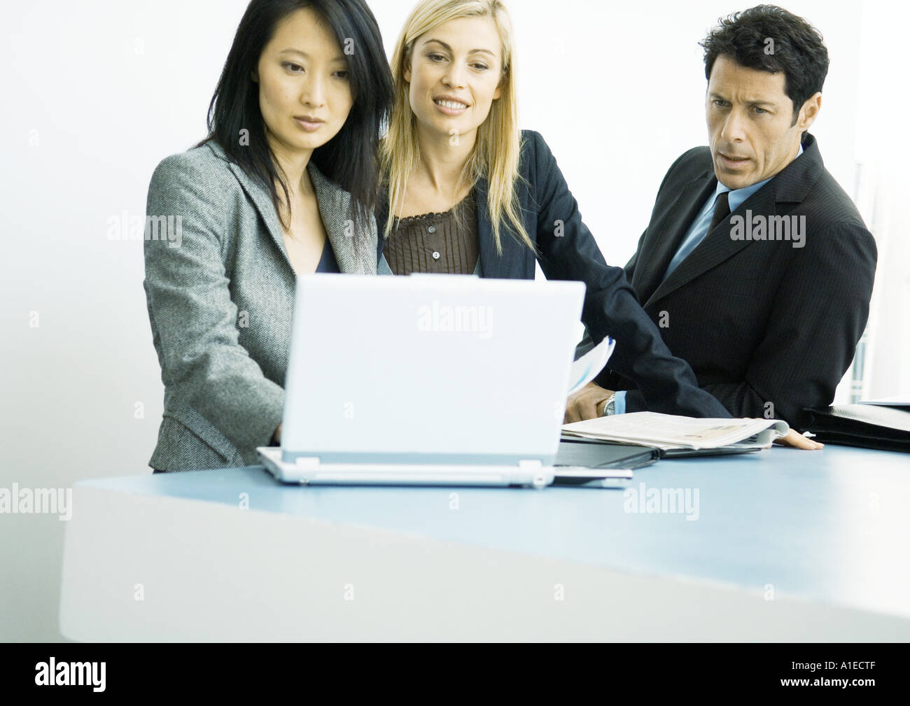 Businesspeople working on laptop together Stock Photo