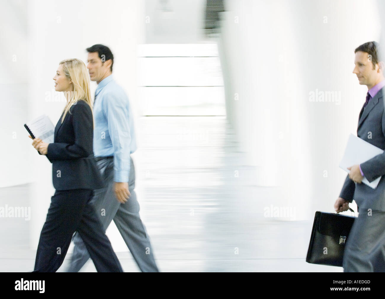 Businesspeople walking through lobby Stock Photo