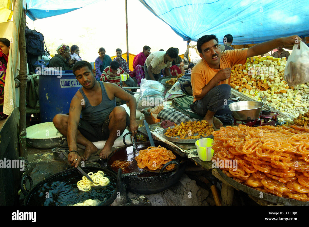 Man frying sweets at Dussehra fair with enormous variety of rich Indian