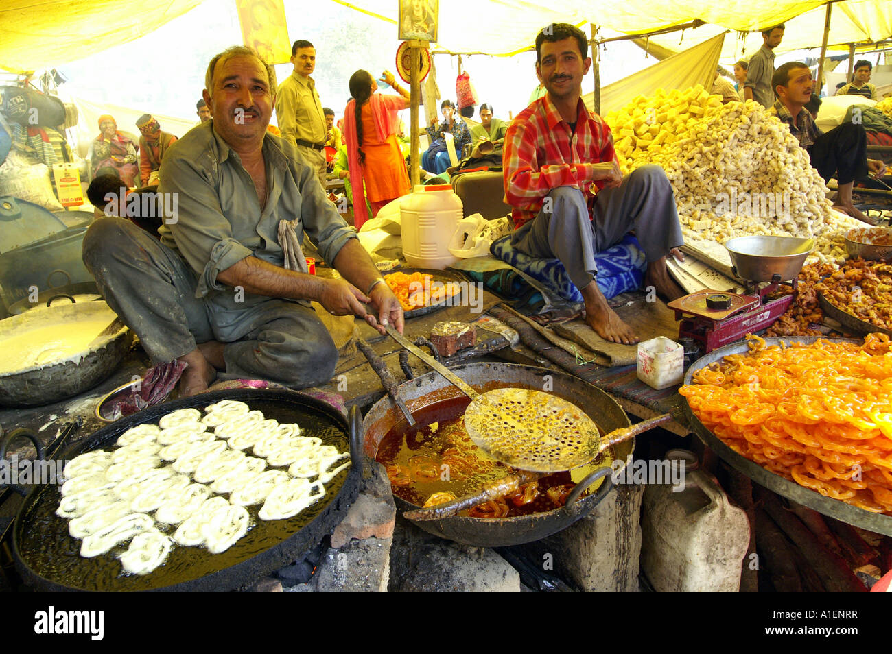 Man frying sweets at Dussehra fair with enormous variety of rich Indian