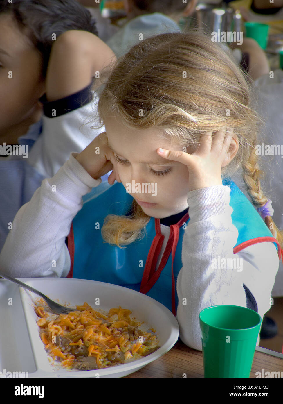 Infant blond girl looks at her school meal in canteen Stock Photo Alamy