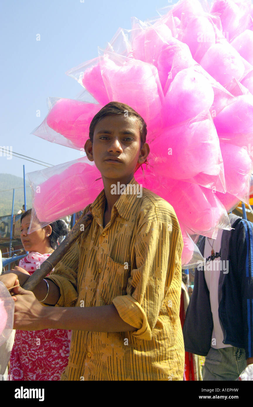 Boy selling pink candy floss bags on stick at Dussehra festival in