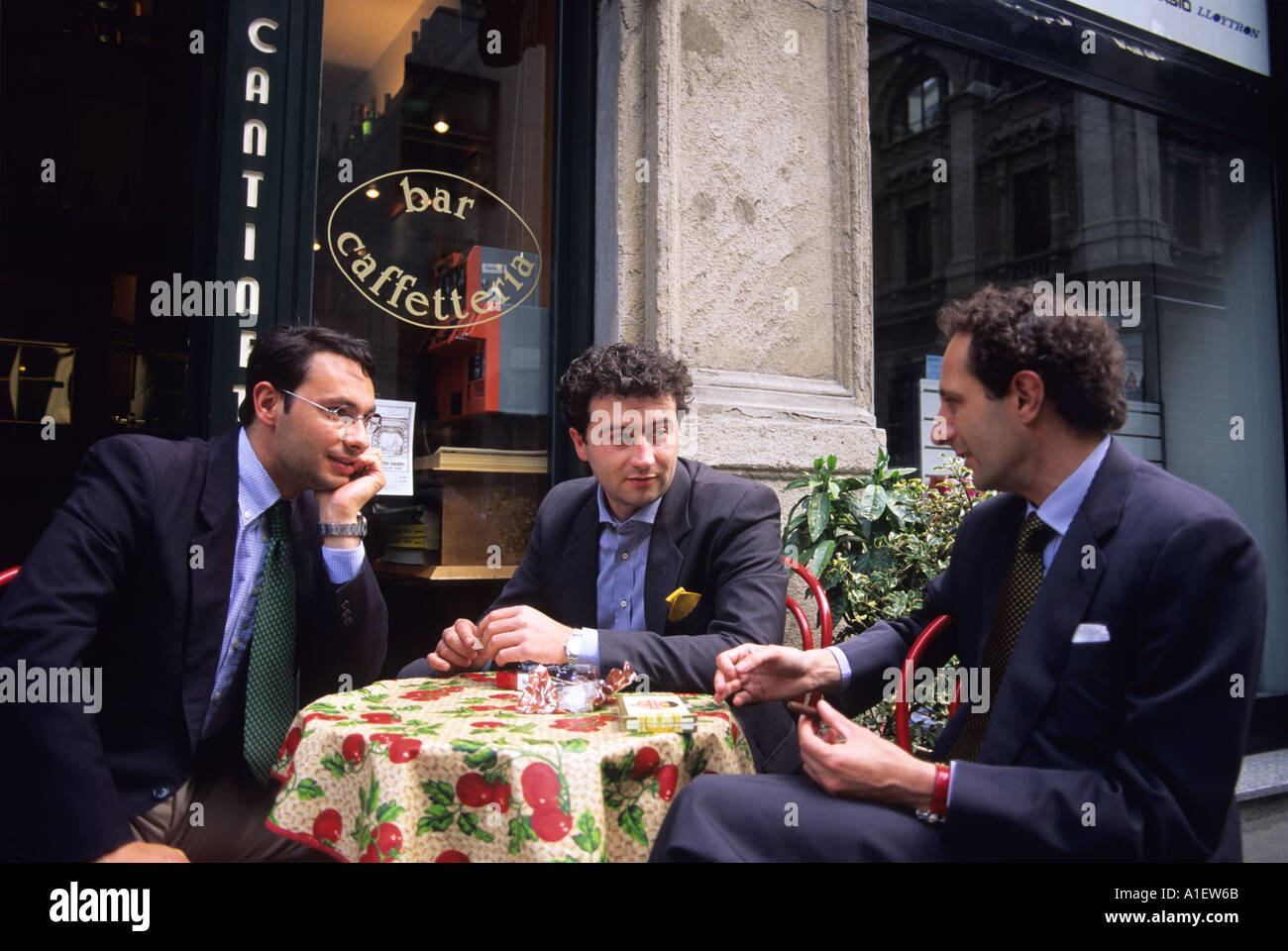 Italian businessmen sitting at a table at an outdoor cafe in Milan