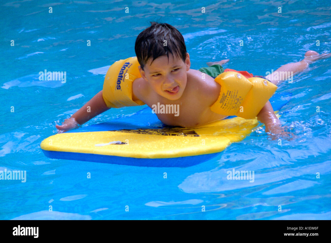 Young boy wading around on a bodyboard Stock Photo - Alamy