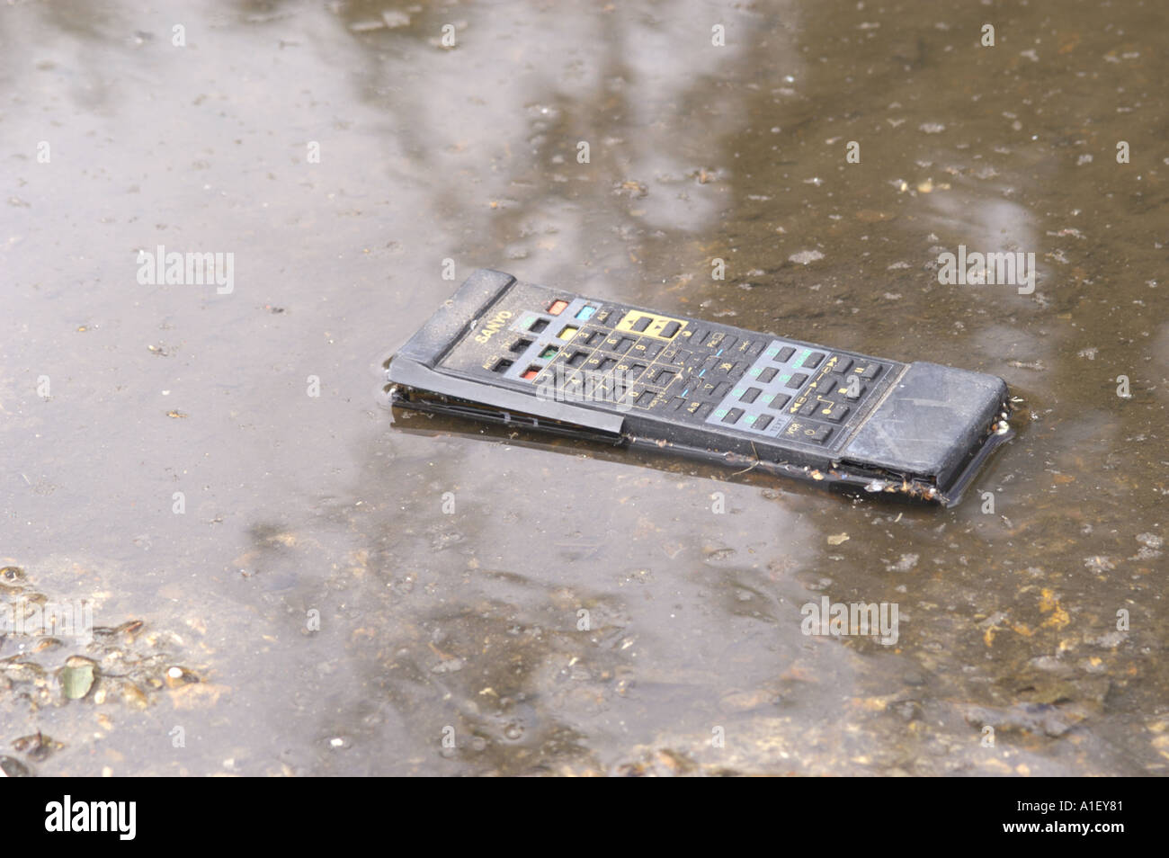 Television remote control lying in water at a recycling centre in