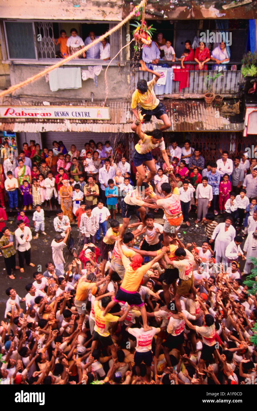 Large gropu of men climbing over eachother to create a human pyramid Govinda Dahi Handi India Stock Photo