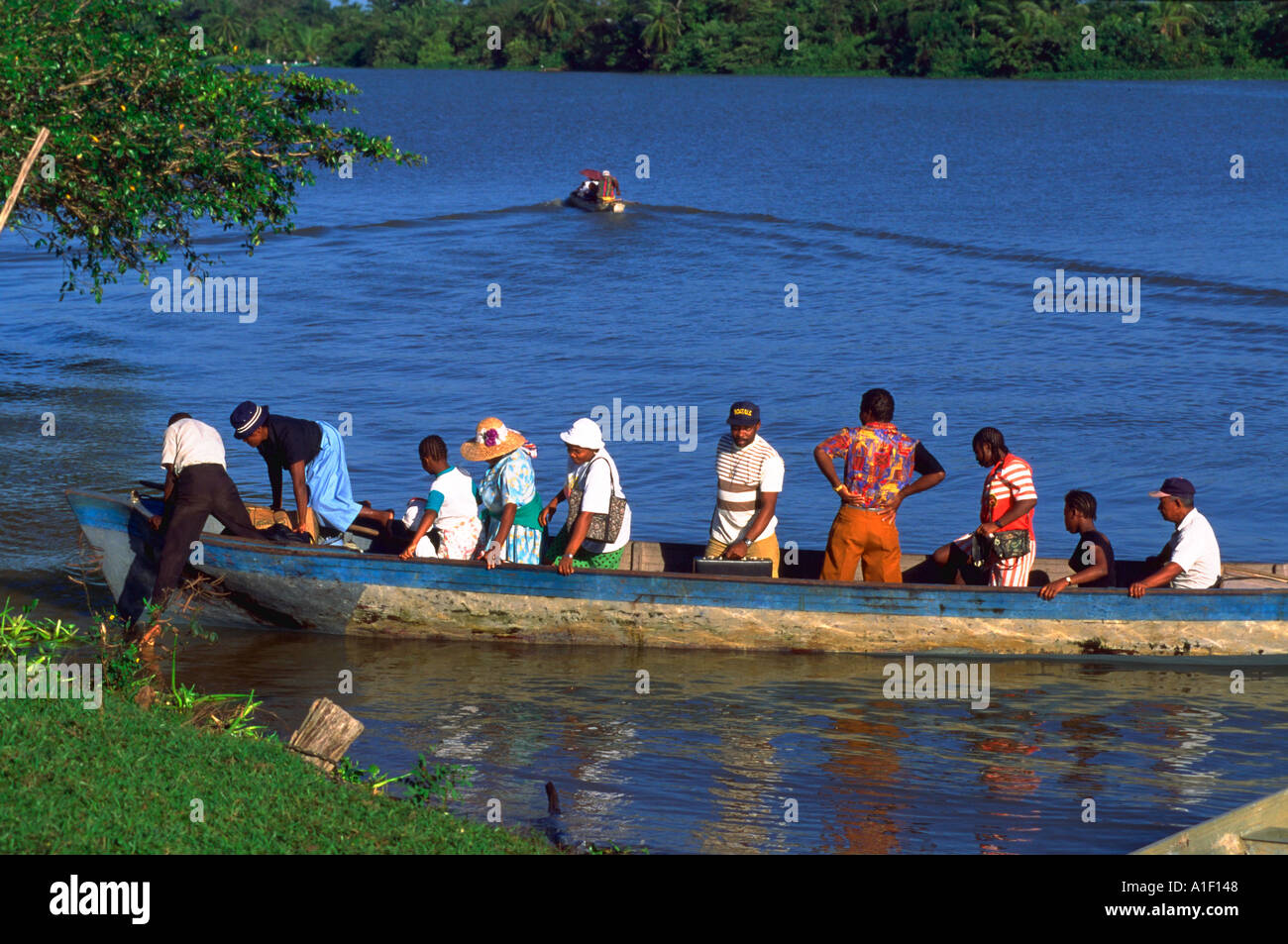 Groupo f Garifuna people in dugout boat arriving at Palacios Honduras Stock Photo