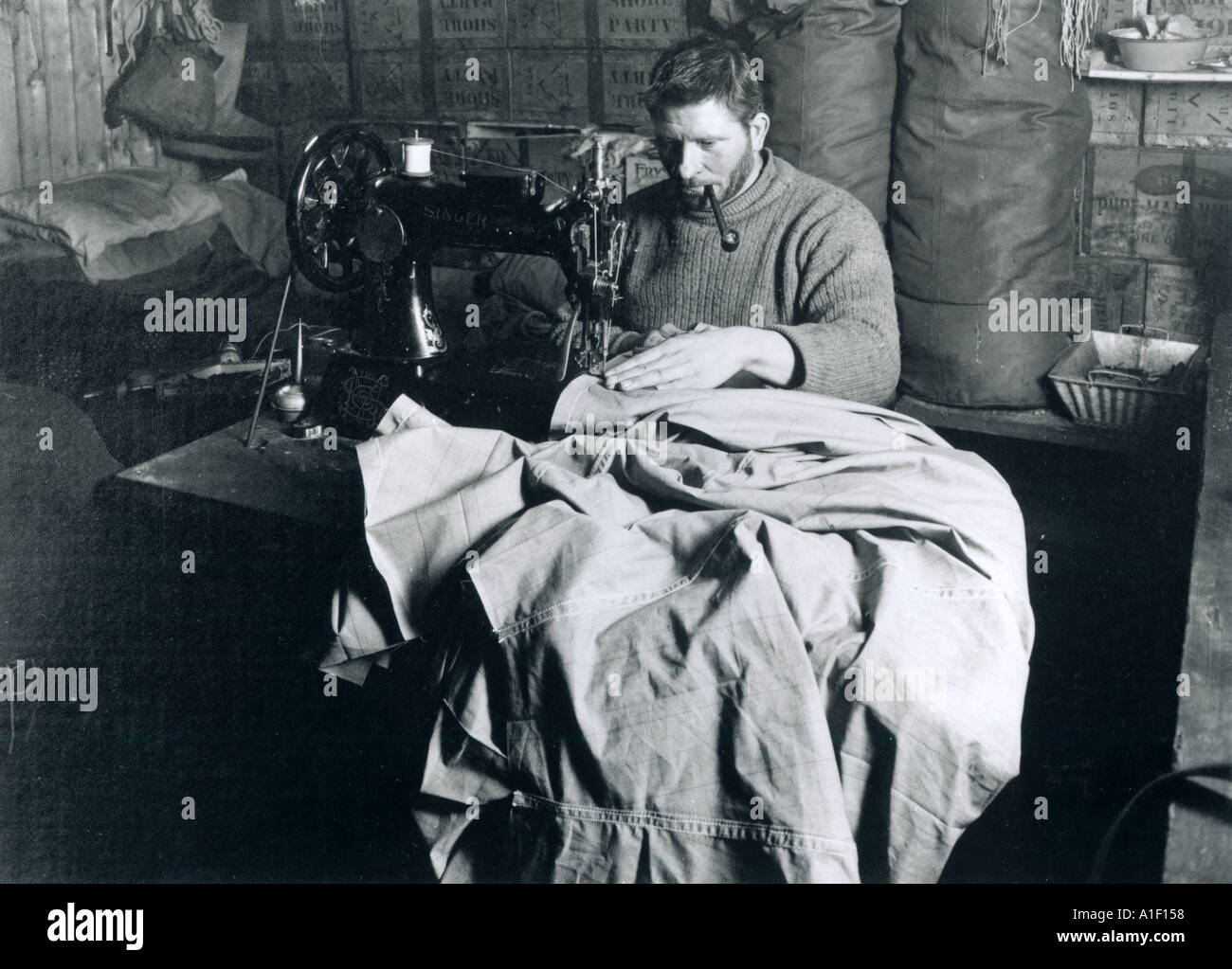 Petty Officer Evans at the sewing machine overhauling sleeping bags and tents Stock Photo