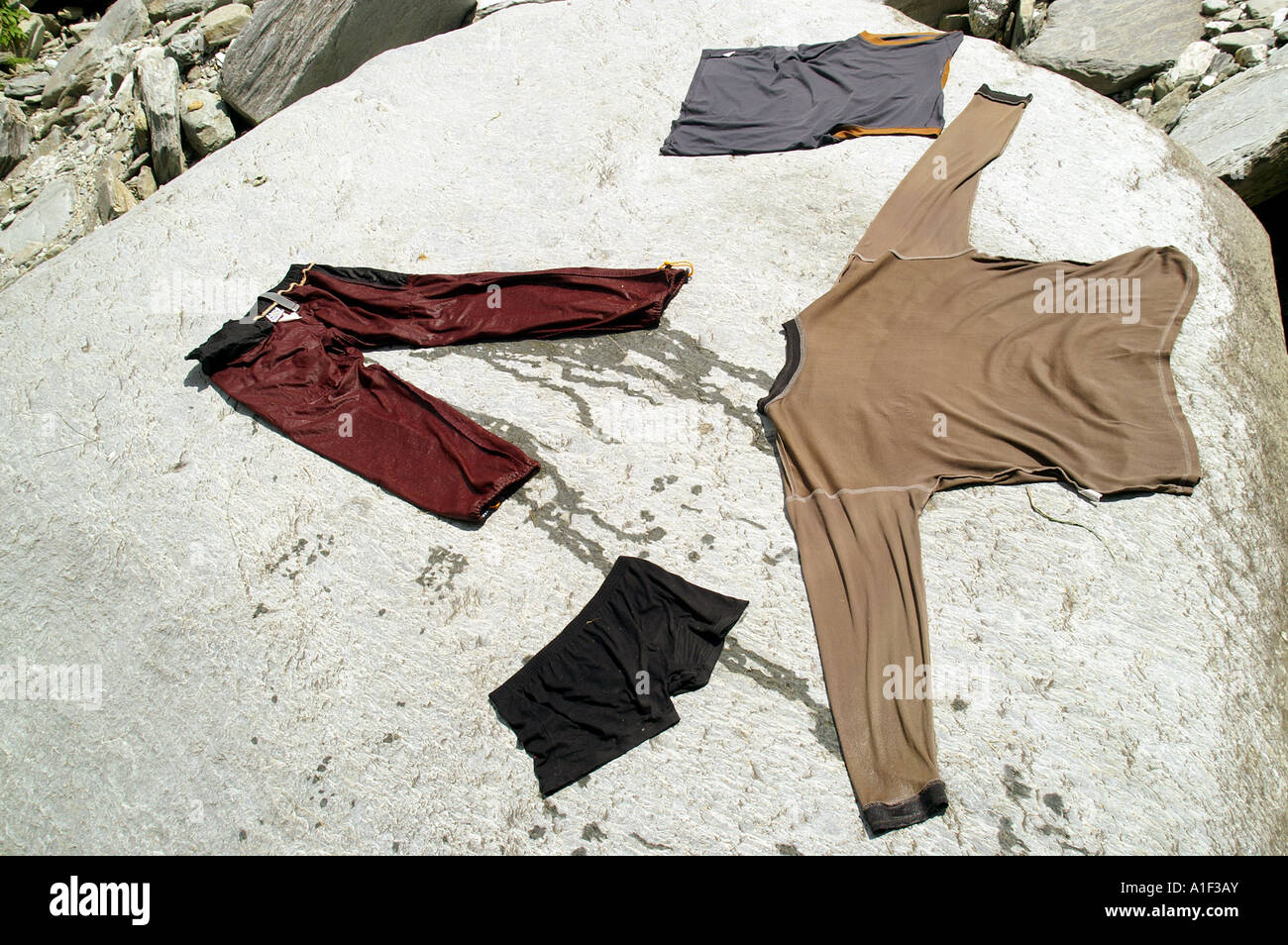 Set of clothes drying on sun on flat stone Stock Photo - Alamy