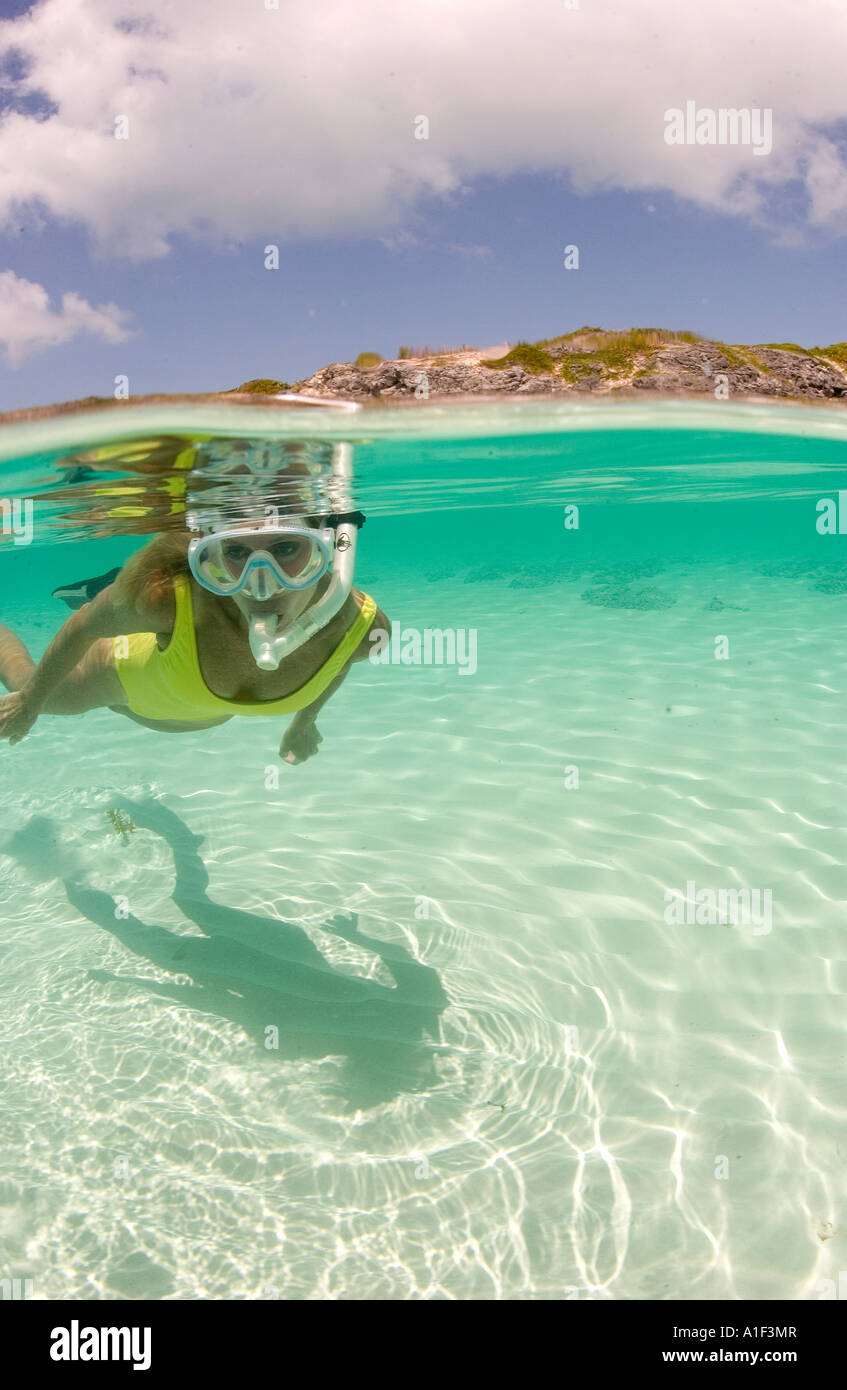 A MATURE WOMAN SNORKELERS IN THE CLEAR SHALLOW WATER OF AN ISLAND IN THE EXUMA CHAIN BAHAMAS Stock Photo